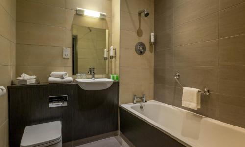 科克科克市尚登马德龙酒店的带浴缸、盥洗盆和卫生间的浴室