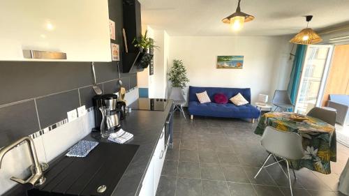 加普Marguerite-Gap Centre的厨房以及带蓝色沙发的客厅。