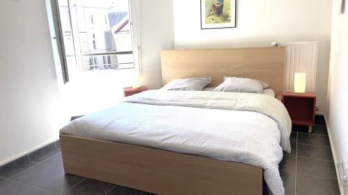 加普Marguerite-Gap Centre的卧室配有一张带白色床单的大床和窗户。