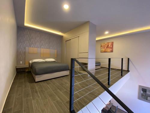 帕丘卡德索托Loft Platino的一间卧室设有一张床和一个楼梯