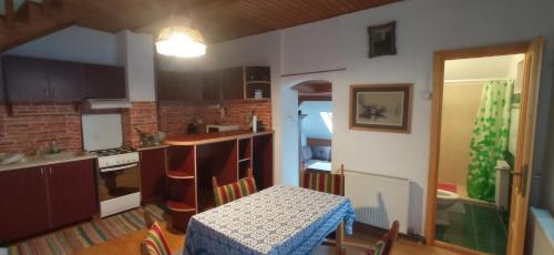 博尔塞克Casa de vacanta - Vendeghaz的厨房配有桌子和桌子,设有用餐室。