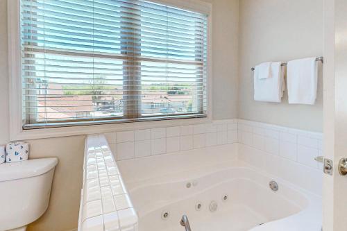 海伦Riverside Trout Cottage的白色的浴室设有浴缸和窗户。