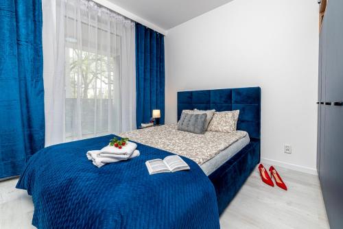 比得哥什Premium Wrocławska Apartament Parking的一间卧室配有蓝色的床和两本书