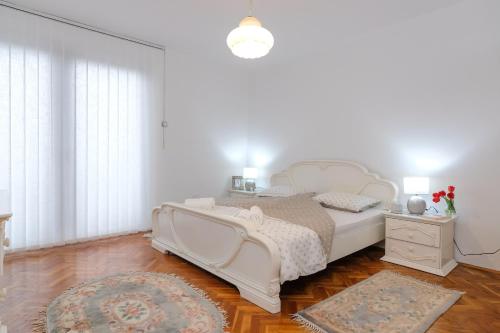 维索科The Cosmic Gate Apartments的白色卧室配有白色的床和地毯
