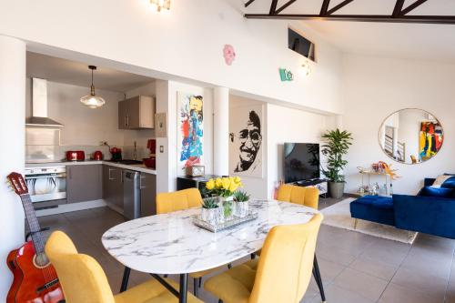 阿维尼翁L’Avant Scène - Loft de Luxe - Atelier d'artiste的厨房以及带桌椅的起居室。