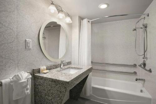 威廉斯堡威廉斯堡康福特茵酒店的一间带水槽、浴缸和镜子的浴室