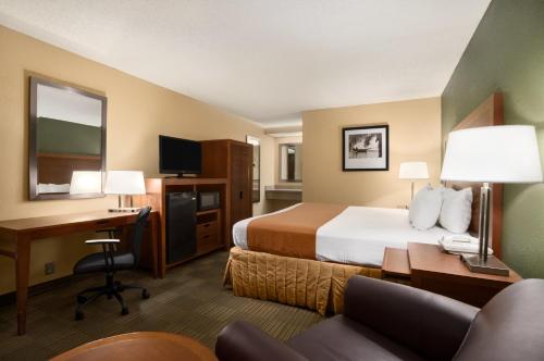 杰克逊维尔杰克逊维尔机场戴斯酒店的配有一张床和一张书桌的酒店客房