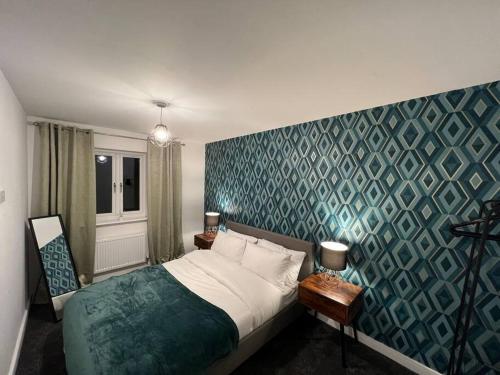 德比3 Bed house, Derby City Centre leisure or Business的一间卧室设有一张床和蓝色的墙壁