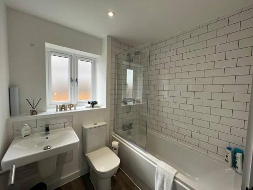 德比3 Bed house, Derby City Centre leisure or Business的白色的浴室设有水槽、卫生间和浴缸。