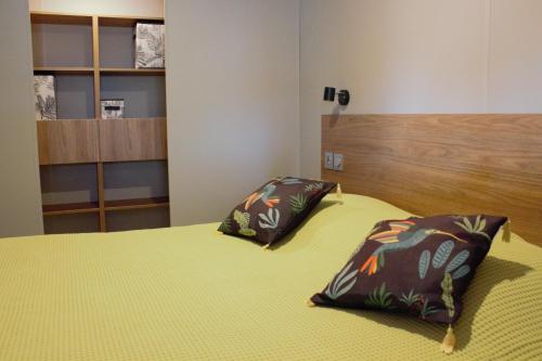 耶尔Mobil Home neuf Hyères的一间卧室配有一张带两个枕头的床