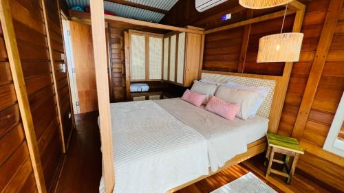 蜜岛Ilha do Mel Lodges的一间卧室配有一张带两个粉红色枕头的床