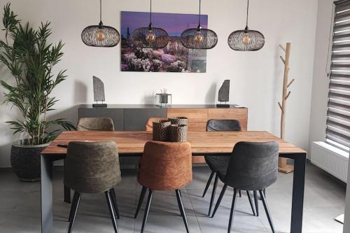 沙勒罗瓦L'escale tout confort的一间带木桌和椅子的用餐室