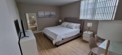 好莱坞NEW LUXURY APARTMENT 2Br 2Ba DIRECT BEACH ACCESS的一间小卧室,配有一张床和电视