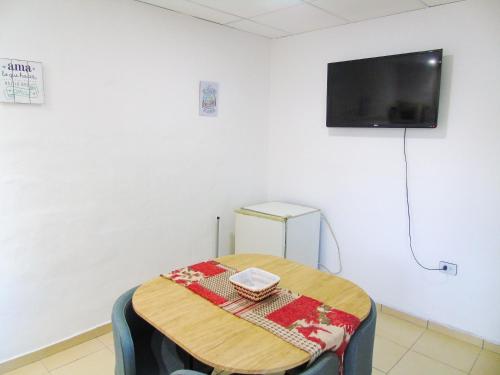 拉里奥哈Comodo y Practico departamento的一间设有桌子的房间和墙上的电视