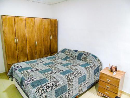拉里奥哈Comodo y Practico departamento的一间卧室配有一张床和一个木制橱柜