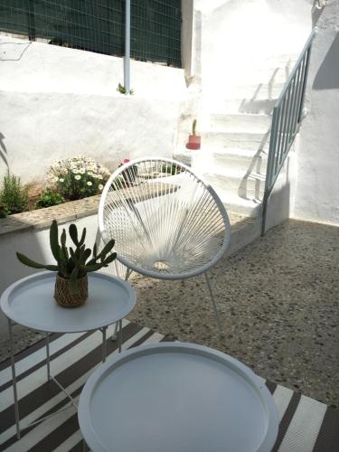 雅典Cozy house with backyard at Iraklio Attikis的庭院配有白色椅子和桌子
