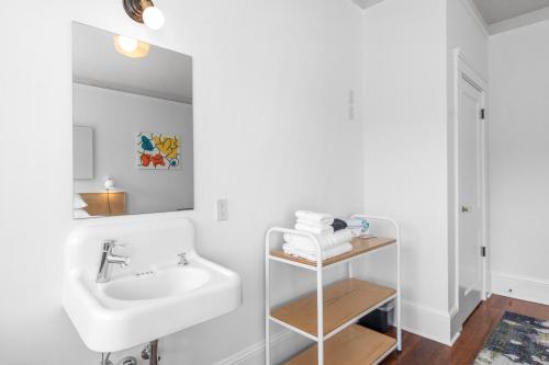 阿斯托里亚Norblad Hotel的白色的浴室设有水槽和镜子