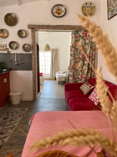 SalirMonte Carrascal Guesthouse的客厅配有红色的沙发和墙上的盘子