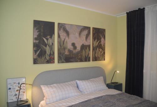 万根沃格Seeluft 33的卧室配有一张墙上三幅画作的床