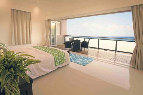 MisereTriplex Villa & Private Pool - CliffHanger Villas的一间卧室设有海景阳台