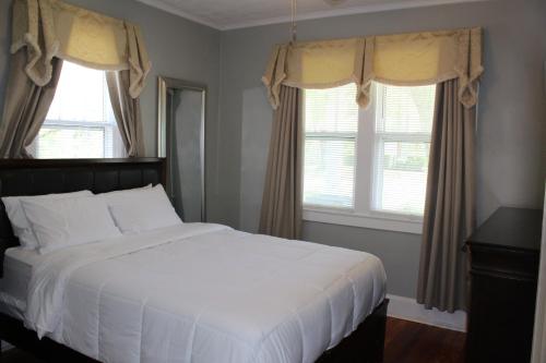 列克星敦The Flower Pot的卧室配有白色的床和2扇窗户。