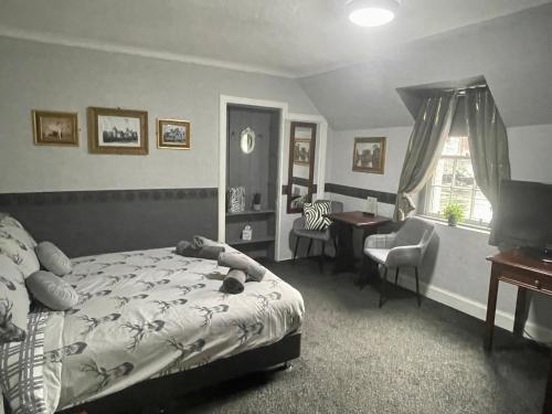 佩尼库克Navaar House Hotel的一间卧室配有一张床、一张桌子和一把椅子