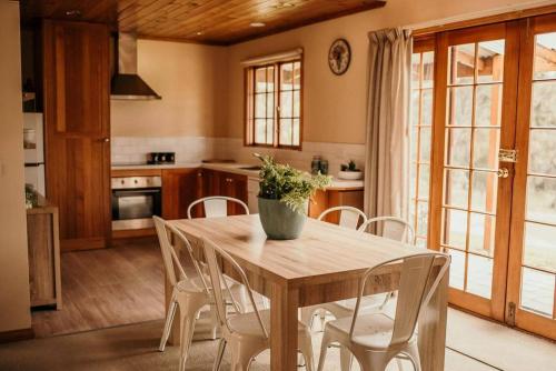 霍巴特奥塔戈住宿加早餐旅馆的厨房配有木桌和白色椅子