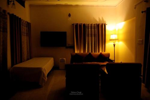 瓦拉纳西Tattva Luxurious Apartment的一间卧室配有一张床、一台电视和一张沙发