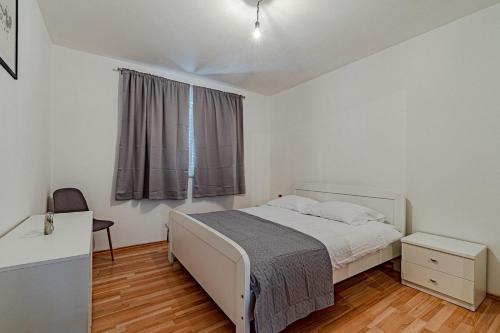 泽尔诺沃Holiday house with a parking space Zrnovo, Korcula - 21067的卧室配有白色的床和窗户。