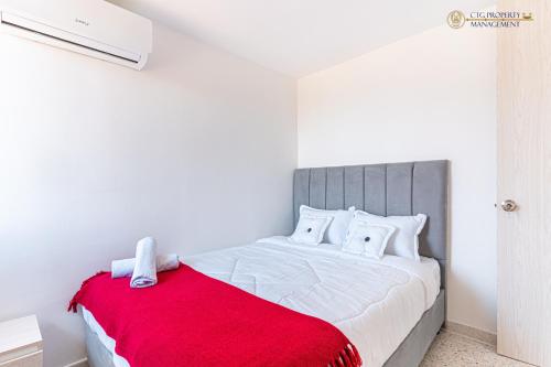 巴兰基亚Coco Paraiso Baranquilla - Hermoso Apartamento Cercano Al Malecón Del Rio的一间卧室配有一张带红色毯子的大床