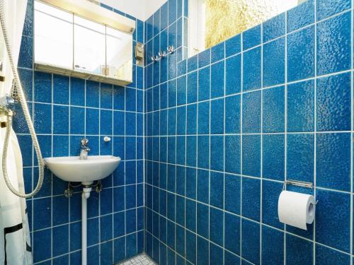 霍伊比Holiday home Højby III的蓝色瓷砖浴室设有水槽和镜子