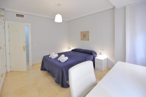 科尔多瓦Albéniz的白色卧室,配有带毛巾的床