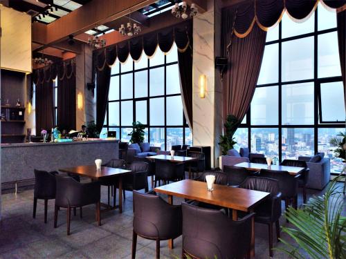 西哈努克Legend Hotel and Resort的餐厅设有桌椅和大窗户。