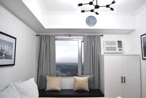 卡加盐德奥罗New York Suite III at Avida Towers Aspira的客房设有窗户和一张带枕头的沙发。