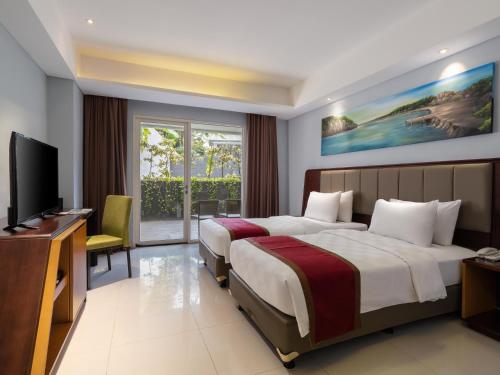 棉兰d'primahotel Kualanamu Medan Formerly Prime Plaza Hotel的酒店客房设有两张床和一台平面电视。