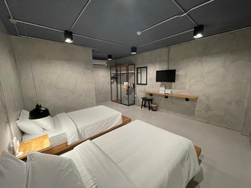 拉廊Loft Space Hotel的一间带两张床的卧室和一台电视