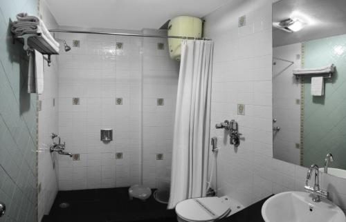 穆索里马苏里蜜月酒店的带淋浴、卫生间和盥洗盆的浴室