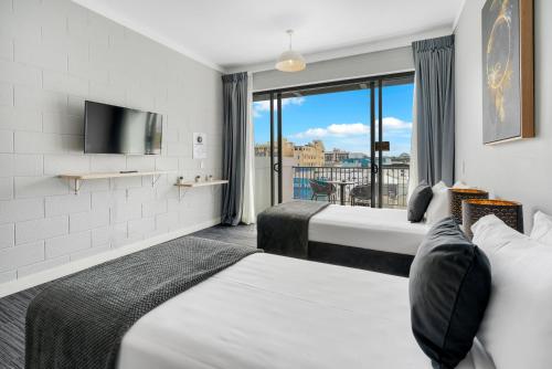 凯恩斯Gilligan's Hotel & Resort Cairns的酒店客房设有两张床和窗户。