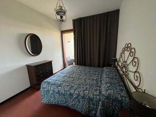 奥尔贝泰洛Villa Giannella的一间卧室配有一张床、梳妆台和镜子