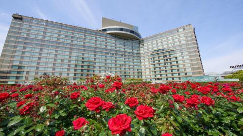 东京Hotel New Otani Tokyo EXECUTIVE HOUSE ZEN的前面有红玫瑰的大建筑