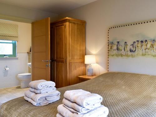 GrangePetronella的浴室的床上有一堆毛巾