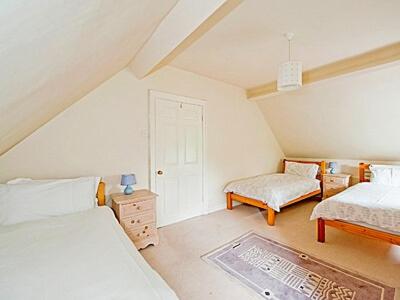 戈斯兰Eversfield的阁楼卧室配有两张床和椅子