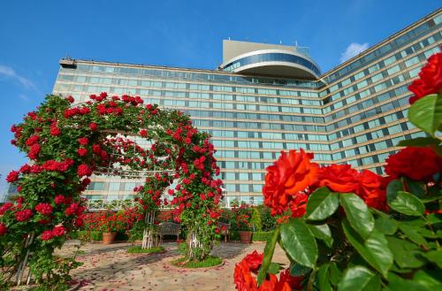 东京Hotel New Otani Tokyo The Main的一座大建筑,前面有红花