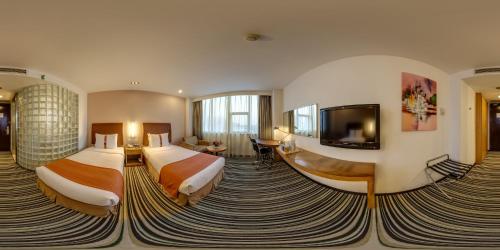 上海上海金桥中心智选假日酒店的酒店客房设有两张床和一台平面电视。