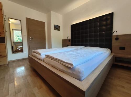 拉纳Rebleitenhof的卧室内的一张大床和黑色床头板