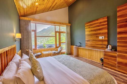 本贾尔Doris Mountain Cabins Tirthan的一间卧室设有一张大床和一个大窗户