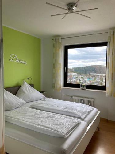 温特贝格Ferienwohnung Heidi Winterberg的一间卧室设有一张大床和窗户