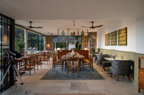 努沃勒埃利耶斯塔福德别墅酒店的用餐室设有桌椅和窗户。