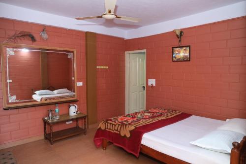 马迪凯里Sai Home Stay的一间卧室设有红砖墙、一张床和镜子