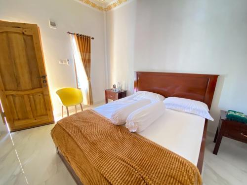 比拉Rumah Windy Guest House Bira的一间卧室配有一张大床和木制床头板